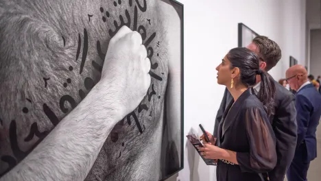 Photo of visitor looking at Shirin Neshat's work.