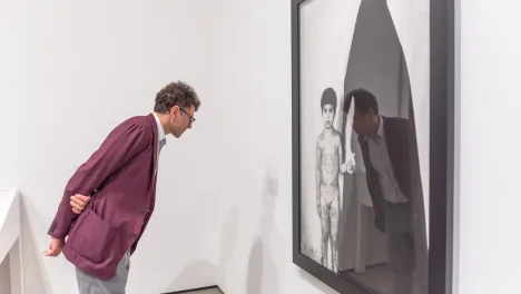 Photo of visitor looking at Shirin Neshat's work.