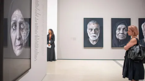 Photo of visitor looking at Shirin Neshat's work.