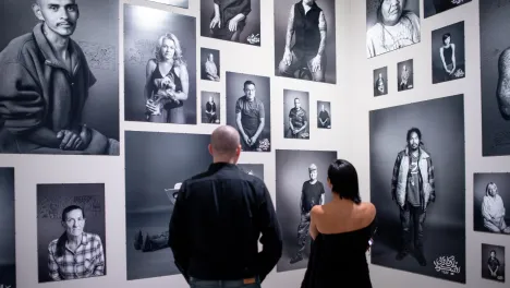 Photo of visitors looking at Shirin Neshat's work.