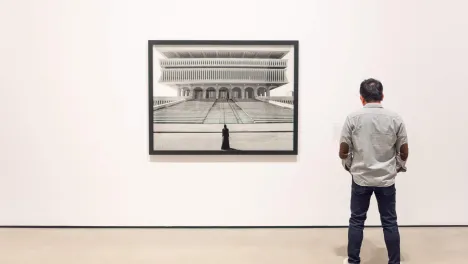 Photo of visitor looking at Shirin Neshat's work.