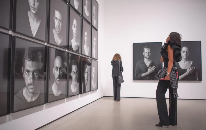 Photo of visitor looking at Shirin Neshat's works.