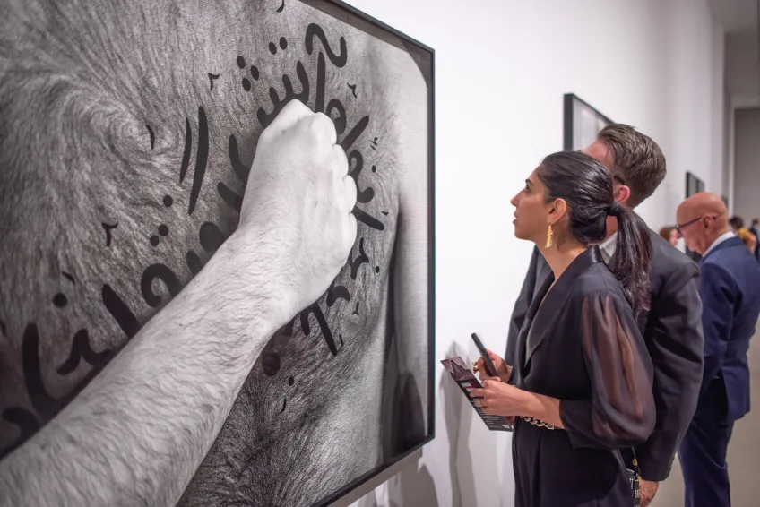 Photo of visitor looking at Shirin Neshat's work.