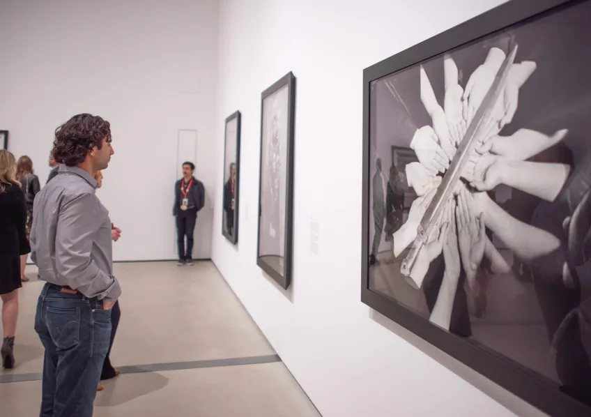 Photo of visitor looking at Shirin Neshat's work.