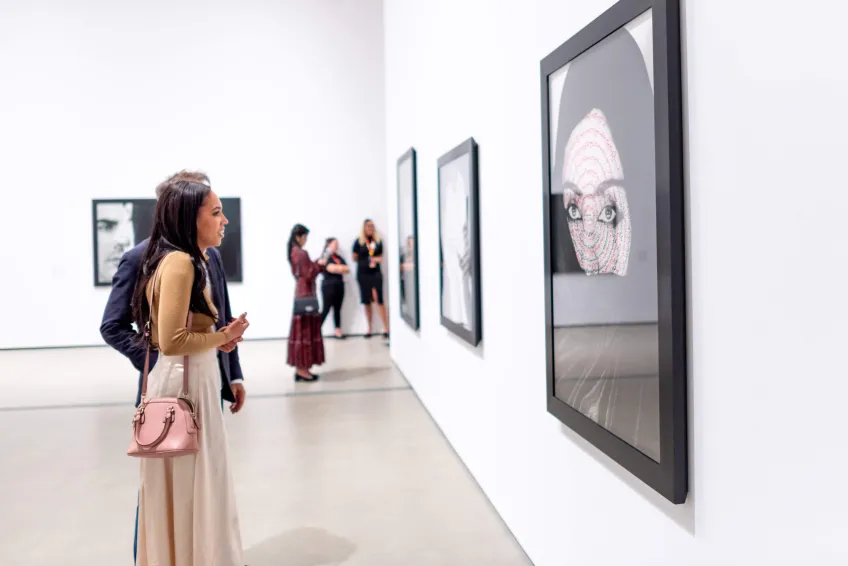 Photo of visitor looking at Shirin Neshat's work.